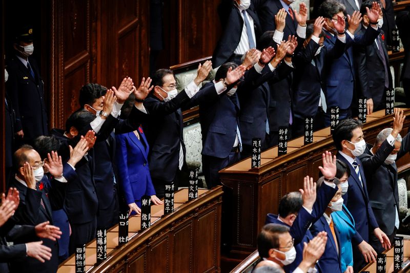 © Reuters. Japan's Prime Minister and the leader of the ruling Liberal Democratic Party (LDP) Fumio Kishida and his cabinet ministers raise their hands and shout 
