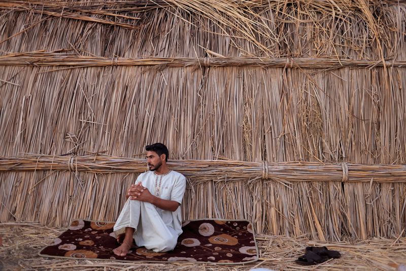 &copy; Reuters. Sabah Thamer al-Baher sits at his home in the Chebayesh marsh, Dhi Qar province, Iraq, August 15, 2021. Iraq's 2020-2021 rainfall season was the second driest in 40 years, according to the United Nations, causing the salinity of the wetlands to rise to da