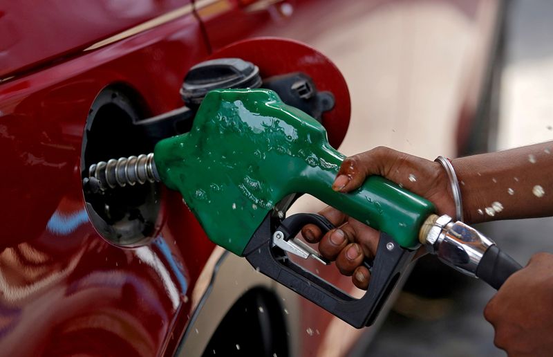 &copy; Reuters. FILE PHOTO: A worker holds a nozzle to pump petrol into a vehicle at a fuel station in Mumbai, India