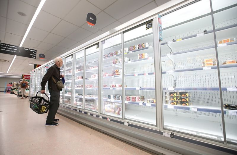 © Reuters. A shopper looks at produce and empty shelves of the meat aisle in Co-Op supermarket, Harpenden, Britain, September 22, 2021.  REUTERS/Peter Cziborra 