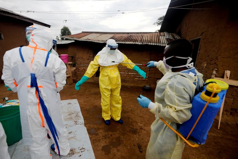 &copy; Reuters. Kavota Mugisha Robert, un trabajador de la salud, que se ofreció como voluntario en la respuesta al ébola, descontamina a su colega después de que ingresó a la casa de una mujer de 85 años, sospechosa de morir de ébola, en la ciudad congoleña orien