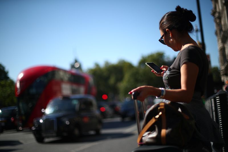 &copy; Reuters. FILE PHOTO: A women looks at her mobile phone in central London, Britain, September 13, 2018. REUTERS/Hannah McKay