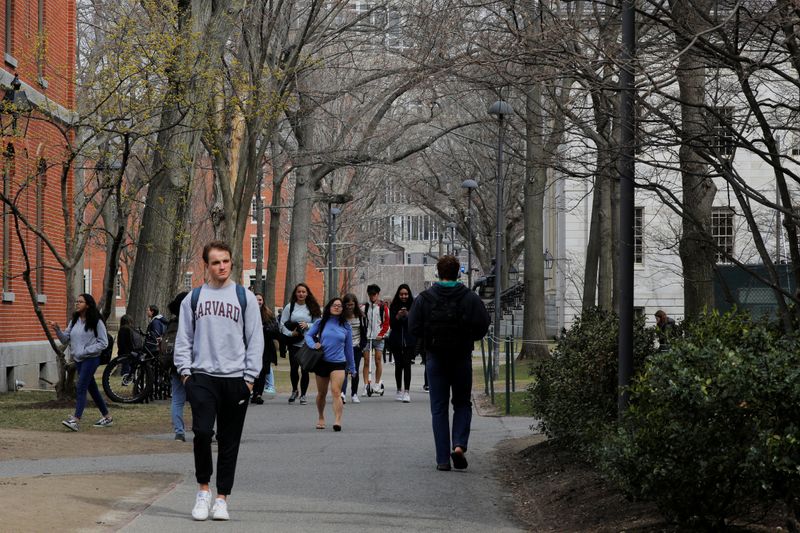 &copy; Reuters. FILE PHOTO: Students and pedestrians walk through the Yard at Harvard University, after the school asked its students not to return to campus after Spring Break and said it would move to virtual instruction for graduate and undergraduate classes, in Cambr