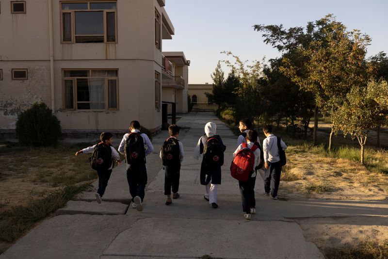 &copy; Reuters. Samira, 9, and other children from the orphanage walk to the school bus in Kabul, Afghanistan, October 12, 2021. Samira wants to be a doctor when she grows up. "I want to serve my homeland and save others from disease, and I also want other girls to study