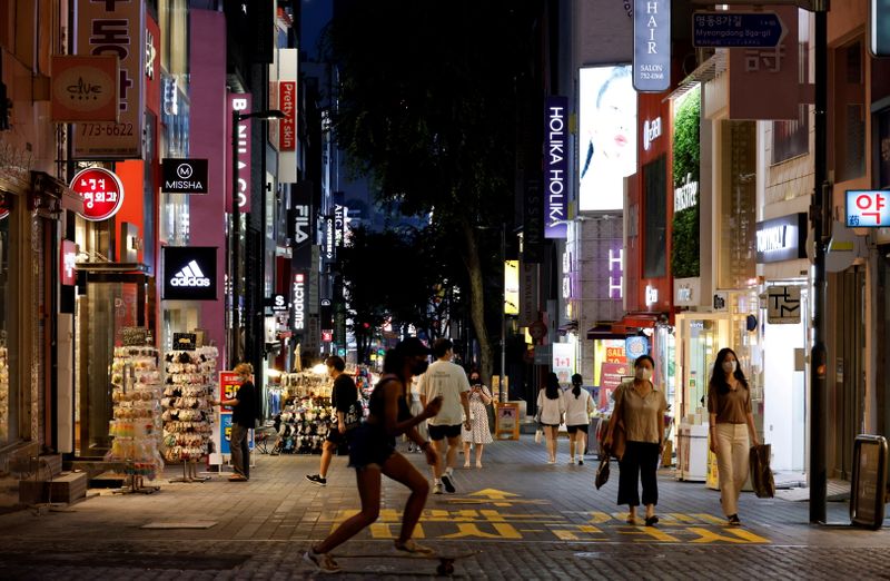 &copy; Reuters. FILE PHOTO: A woman skateboards on a shopping street amid tightened social distancing rules due to the coronavirus disease (COVID-19) pandemic in Seoul, South Korea, July 12, 2021.  REUTERS/Heo Ran/File Photo