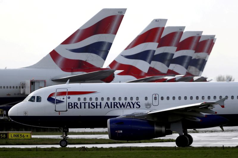 &copy; Reuters. FOTO DE ARCHIVO: Un avión de British Airways pasa junto a las aletas de cola de los aviones aparcados cerca de la Terminal 5 del aeropuerto de Heathrow en Londres, el Reino Unido, 14 de marzo de 2020. REUTERS/Simon Dawson/File Photo