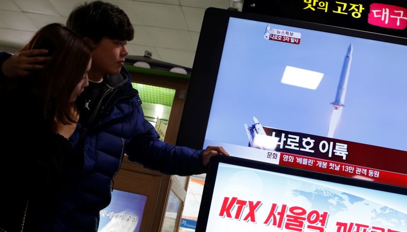 &copy; Reuters. Una pareja ve un informe de televisión que transmite el lanzamiento del cohete espacial de Corea del Sur en el Centro Espacial Naro en Goheung en una estación de tren en Seúl, Corea del Sur, 30 enero 2013.
REUTERS/Lee Jae-Won