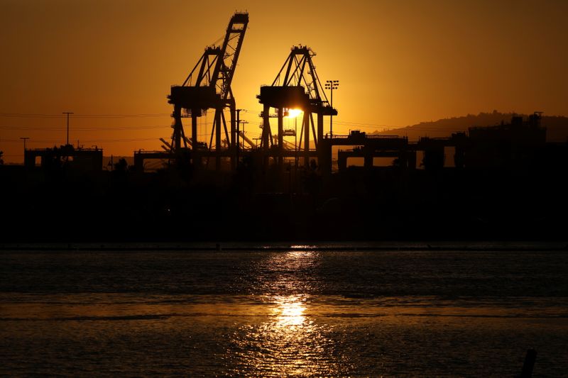 © Reuters. The sun sets behind container cranes at the Port of Los Angeles in Los Angeles, California, U.S. October 14, 2021.  REUTERS/David Swanson/Files