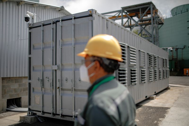 © Reuters. A worker is seen next to a container, where a Bitcoin mining facility is installed, at the Berlin geothermal plant of La Geo electrical company, where the Salvadoran government installed a Bitcoin mining facility for the use of bitcoin as legal tender, in Alegria, El Salvador, October 15, 2021. REUTERS/Jose Cabezas