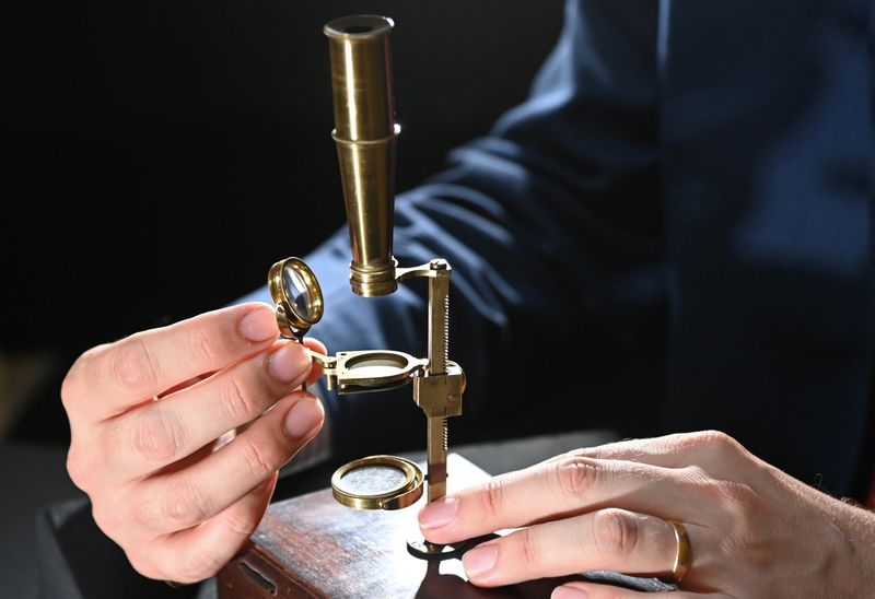 &copy; Reuters. James Hyslop, Head of Scientific Instruments, Globes and Natural History at Christie's, demonstrates the Darwin Family Microscope, owned and used by the English naturalist and founder of the concept of evolution, Charles Darwin, which will be offered at a