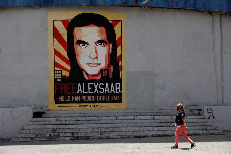 &copy; Reuters. FILE PHOTO: A woman walks by a mural in support of the liberation of Colombian businessman and envoy Alex Saab, who is detained in Cape Verde on charges of laundering money for the government of Venezuelan President Nicolas Maduro, in Caracas, Venezuela S