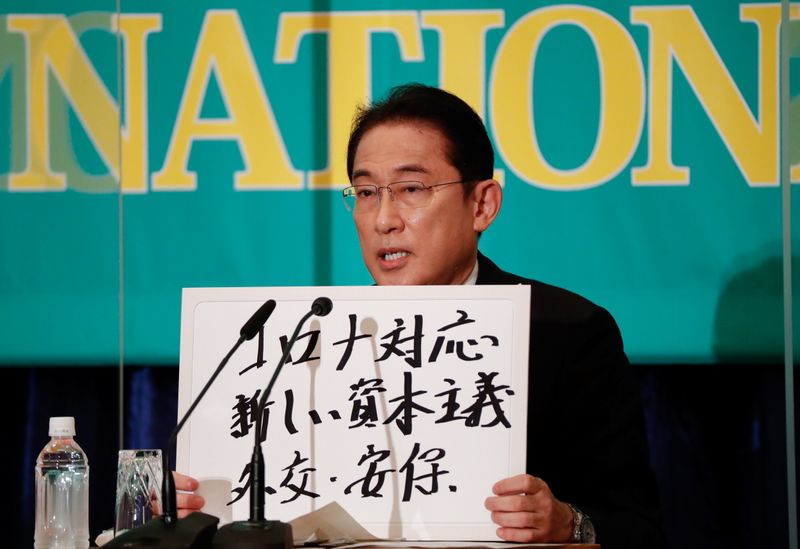 © Reuters. Japan's Prime Minister Fumio Kishida, who is also ruling Liberal Democratic Party President, holds up a placard reading 