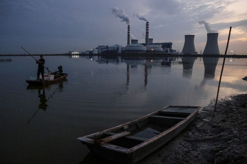 &copy; Reuters. Un pescador navega por un lago frente a la central eléctrica de SDIC en Tianjín