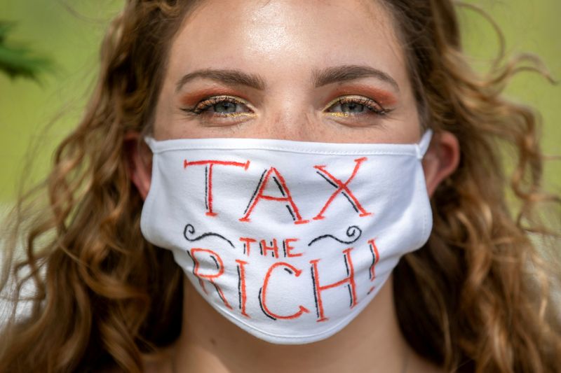 &copy; Reuters. FILE PHOTO: NDP supporter Sophie Reynolds wears a "Tax the Rich" mask during an election campaign visit by New Democratic Party (NDP) leader Jagmeet Singh in Welland, Ontario, Canada September 15, 2021. REUTERS/Nick Iwanyshyn 