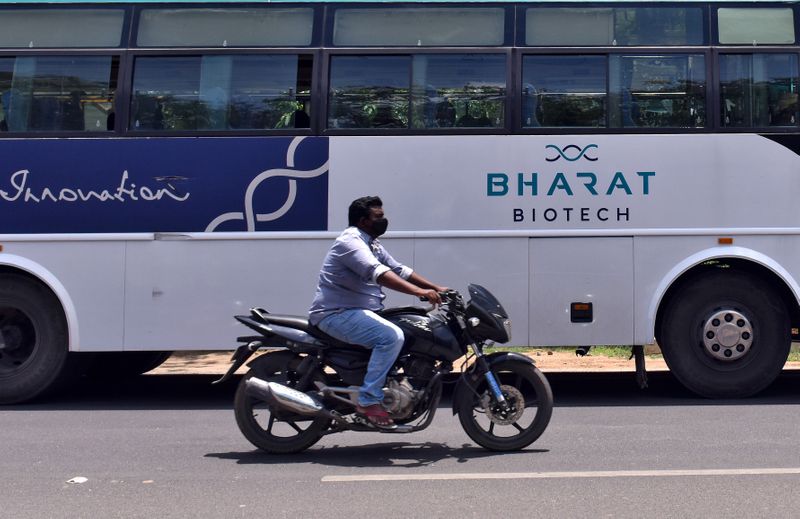&copy; Reuters. FILE PHOTO: A man rides his motorbike past a parked bus of India's biotechnology company Bharat Biotech outside its office in Hyderabad, India July 3, 2020. REUTERS/Stringer