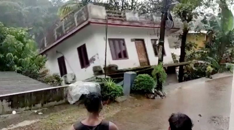 &copy; Reuters. Pessoas observam casa sendo arrastada pela correnteza do rio em Kottayam, na Índia
17/10/2021 Reuters TV/ANI/Escritório de Relações Públicas do Governo de Kerala/ Divulgação via REUTERS 