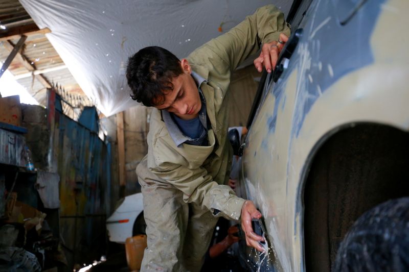 &copy; Reuters. صبي يعمل على إصلاح هيكل سيارة في ورشة بصنعاء يوم الرابع من أغسطس آب 2021. تصوير: نسيبة المعلمي - رويترز