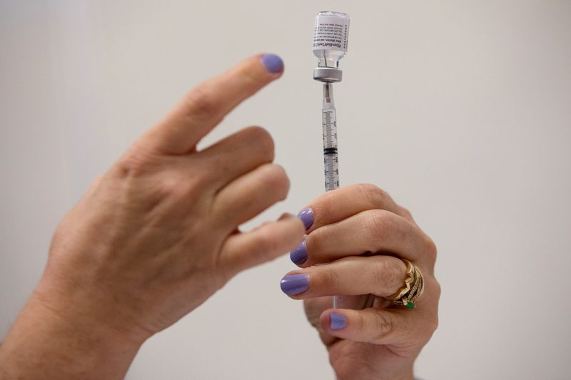 &copy; Reuters. A nurses fills up syringes for patients as they receive their coronavirus disease (COVID-19) booster vaccination during a Pfizer-BioNTech vaccination clinic in Southfield, Michigan, U.S., September 29, 2021.  REUTERS/Emily Elconin
