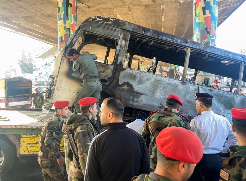 &copy; Reuters. Agentes de la policía militar inspeccionan el lugar donde se produjo la explosión de un autobús en el centro de Damasco, Siria, el 20 de octubre de 2021. REUTERS/Firas Makdesi