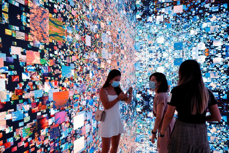 &copy; Reuters. FILE PHOTO: Visitors are pictured in front of an immersive art installation titled "Machine Hallucinations — Space: Metaverse" by media artist Refik Anadol, which will be converted into NFT and auctioned online at Sotheby's, at the Digital Art Fair, in 