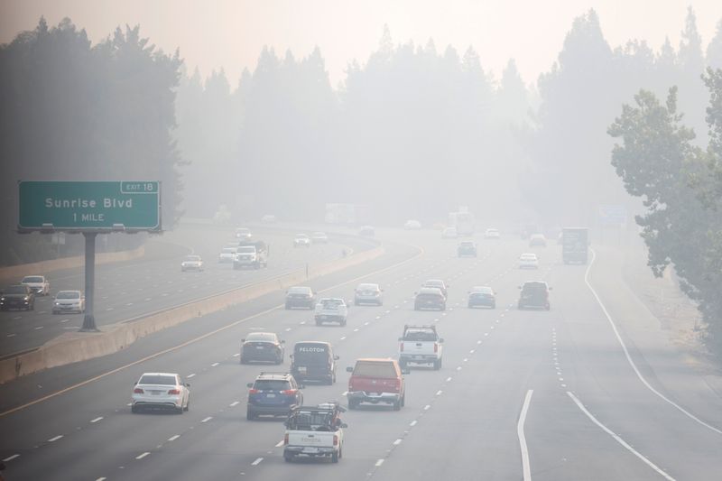 &copy; Reuters. FILE PHOTO: Cars drive along Highway 50 in heavy smoke from Caldor Fire, in Sacramento, CA, U.S., August 28, 2021. REUTERS/Fred Greaves