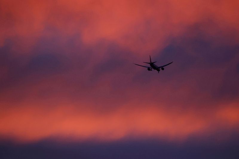 &copy; Reuters. FILE PHOTO: A plane flies in a red sky above London, Britain February 3, 2021. REUTERS/Kevin Coombs/File Photo