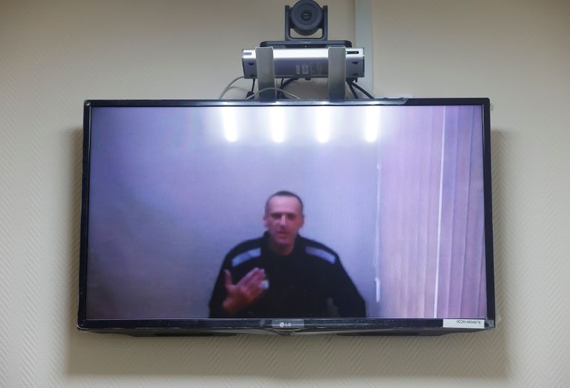 &copy; Reuters. FILE PHOTO: Russian opposition leader Alexei Navalny is seen on a screen via a video link during a hearing to consider his lawsuits against the penal colony over detention conditions there, at the Petushki district court in Petushki, Russia May 26, 2021. 