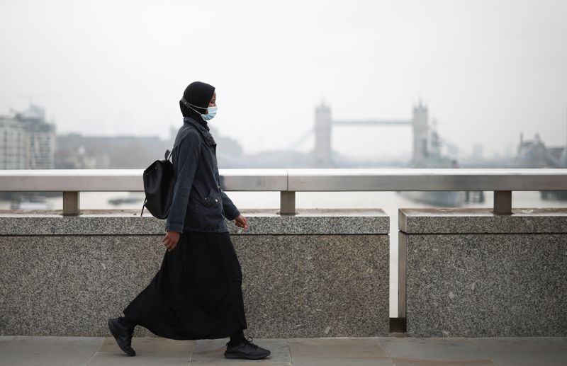 &copy; Reuters. امرأة تضع كمامة للوقاية من فيروس كورونا في لندن يوم أول ابريل نيسان 2021. تصوير: هنري نيكولز - رويترز. 