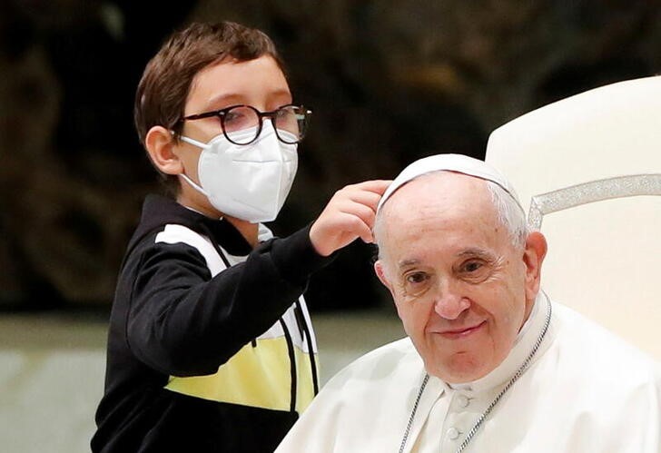 &copy; Reuters. Menino tenta pegar o solidéu do papa no Vaticano
20/10/2021 REUTERS/Remo Casilli 