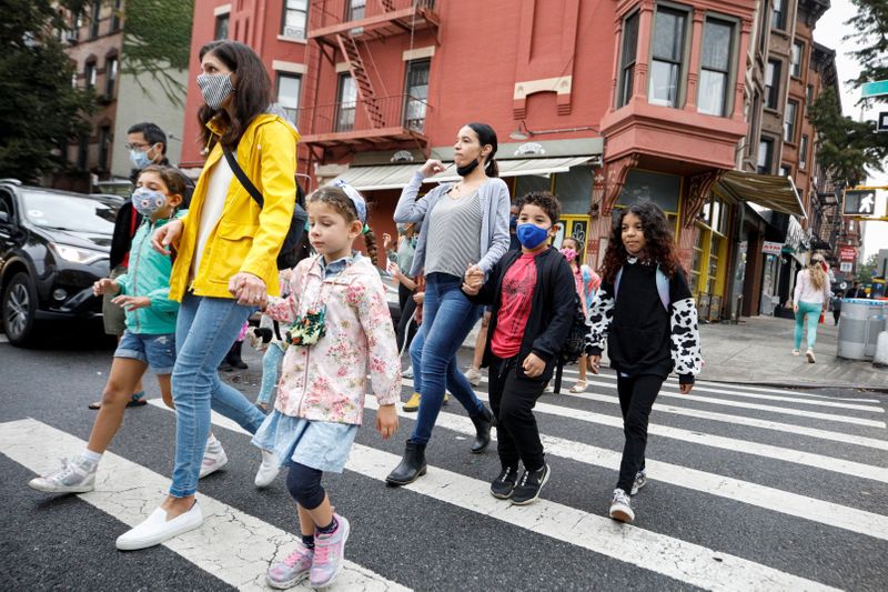 &copy; Reuters. FILE PHOTO: Parents walk with children to school, amid the coronavirus disease (COVID-19) pandemic in Brooklyn, New York, U.S.  October 4, 2021.  REUTERS/Brendan McDermid