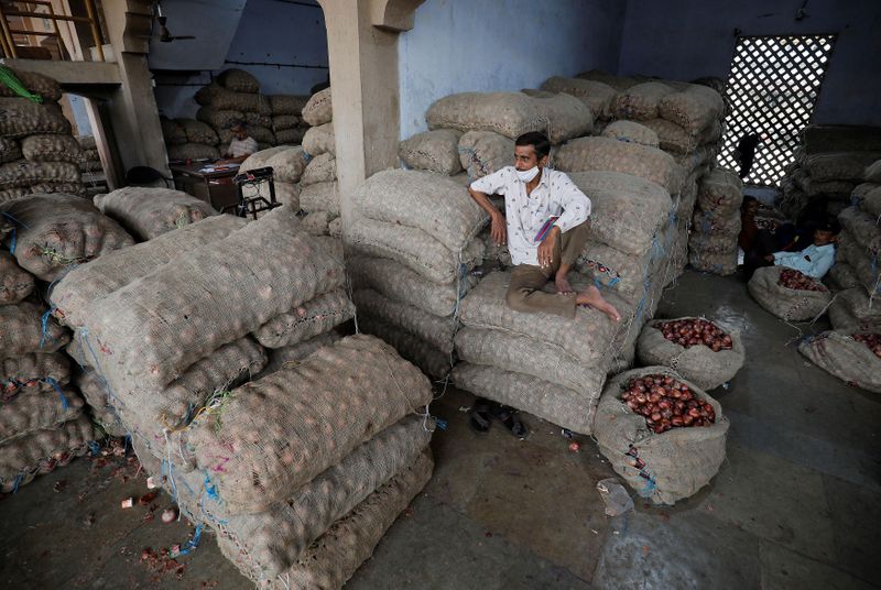 &copy; Reuters. FILE PHOTO: A vendor sits on the sacks of onion as he waits for customers at a vegetable market in Ahmedabad, India, October 11, 2021. Picture taken October 11, 2021. REUTERS/Amit Dave