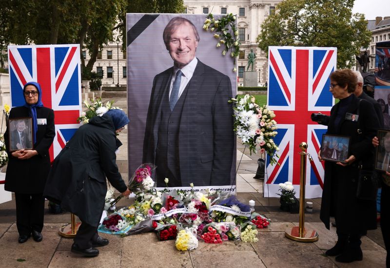 &copy; Reuters. FILE PHOTO: An Anglo-Iranian community member belonging to National Council of Resistance of Iran leaves flowers at a memorial and wall of condolence for British MP David Amess who was stabbed to death during a meeting with constituents at Belfairs Method