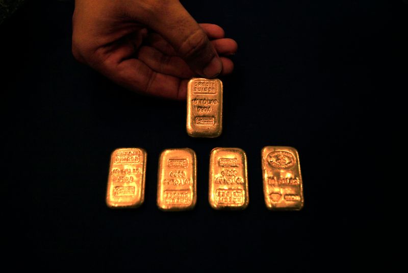 &copy; Reuters. A jeweller displays gold ingots at his shop in Peshawar, northwest Pakistan on September 23, 2010. Gold held near record highs on Thursday, eyeing a breach of $1,300 an ounce, while silver flirted with 30-year peaks as the threat of currency devaluation l