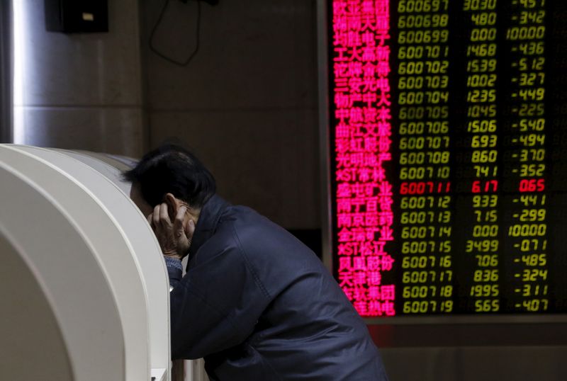 &copy; Reuters. An investor uses a monitor to check stock information on desk in front of  an electronic board showing stock information on the first trading day after the week-long Lunar New Year holiday at a brokerage house in Beijing, China, February 15, 2016. China s