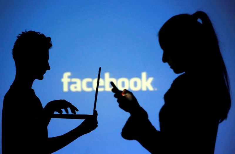 © Reuters. Silhuetas das pessoas posam com laptops em frente a uma tela projetada com o logotipo do Facebook, nesta ilustração fotográfica 
29/10/2014
REUTERS/Dado Ruvic
