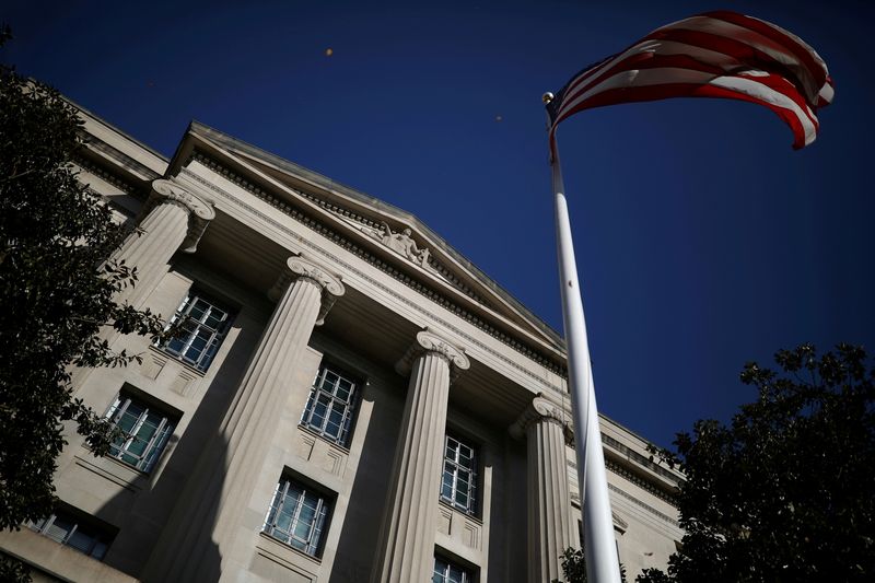 &copy; Reuters. FILE PHOTO: An American flag waves outside the U.S. Department of Justice Building in Washington, U.S., December 2, 2020. REUTERS/Tom Brenner/File Photo/File Photo