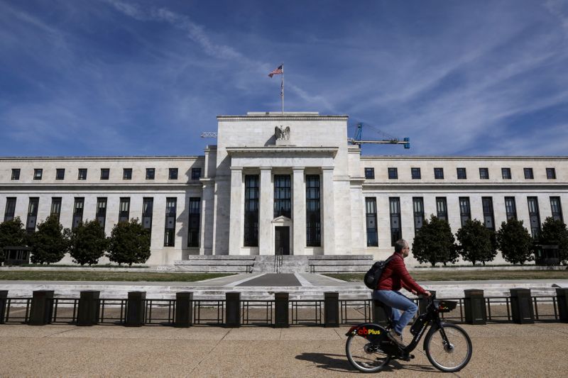 &copy; Reuters. FILE PHOTO: A man rides a bike in front of the Federal Reserve Board building on Constitution Avenue in Washington, U.S., March 27, 2019. REUTERS/Brendan McDermid/File Photo