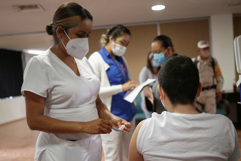 &copy; Reuters. صبي يتلقى جرعة من لقاح فايزر-بيونتيك المضاد لفيروس كورونا في سيوداد خواريز بالمكسيك يوم 19 أكتوبر تشرين الأول 2021. صورة لرويترز.