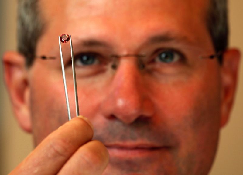 &copy; Reuters. Alan Davies, chief executive of Rio Tinto's diamonds and minerals division, poses with a rare pink diamond in Hong Kong September 6, 2013.    REUTERS/Bobby Yip/File Photo   