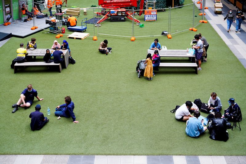 © Reuters. People sit in socially distanced groups in a city shopping complex on the first day of eased coronavirus disease (COVID-19) regulations, following a lockdown to curb an outbreak, in Melbourne, Australia, October 22, 2021. REUTERS/Sandra Sanders