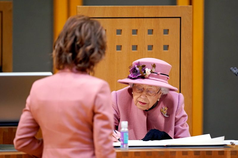 &copy; Reuters. FOTO DE ARCHIVO: La reina Isabel de Inglaterra firma un documento dentro del Siambr (Cámara) durante la ceremonia de apertura del Sexto Senedd en Cardiff, Reino Unido 14 de octubre de 2021. Andrew Matthews/Pool vía REUTERS
