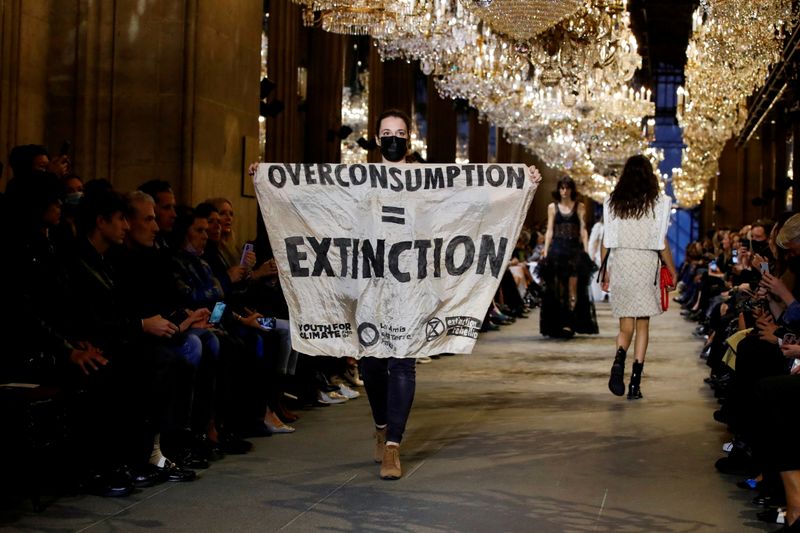 &copy; Reuters. ماري كويت الناشطة المدافعة عن البيئة على الممشى وتحمل لافتة احتجاج خلال عرض أزياء دار لوي فيتون في أسبوع الموضة في العاصمة الفرنسية باريس ف