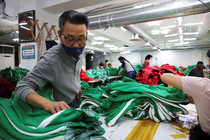 &copy; Reuters. Ko Jong-hyun, de 59 años, propietario de una fábrica de ropa, comprueba la indumentaria recién hecha inspirada en la serie de Netflix "El juego del calamar" en su planta de Seúl, Corea del Sur, el 21 de octubre de 2021. Imagen tomada el 21 de octubre 