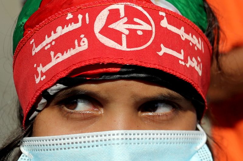 &copy; Reuters. FILE PHOTO: A girl wearing a protective face mask and the headband of the Popular Front for the Liberation of Palestine (PFLP) looks on during a rally to show solidarity with hunger-striking Palestinian prisoner Maher Al-Akhras, who is held by Israel, in 