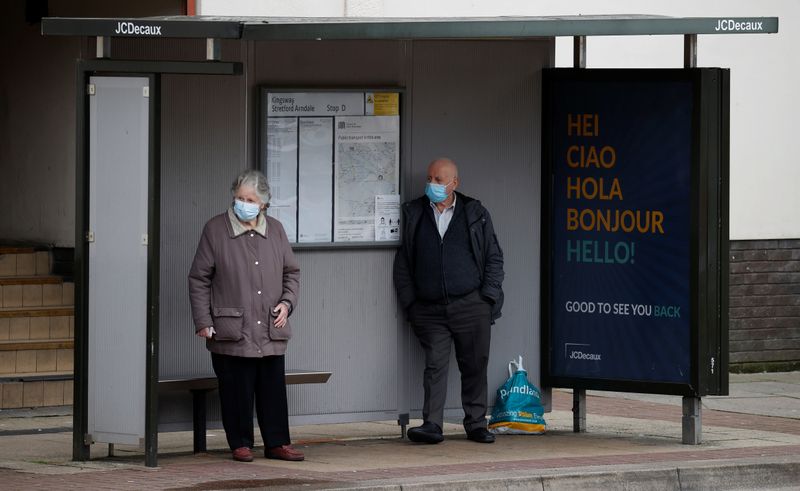 &copy; Reuters. FILE PHOTO: People wear face masks as they stand at a bus stop following the outbreak of the coronavirus disease (COVID-19), in Manchester, Britain, July 8, 2020. REUTERS/Phil Noble
