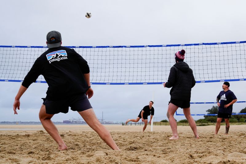 &copy; Reuters. Brendan Alexander plays a game of volleyball with friends at St Kilda West Beach on the second day of eased coronavirus disease (COVID-19) lockdown regulations set to curb the outbreak, in Melbourne, Australia, October 23, 2021. REUTERS/Sandra Sanders