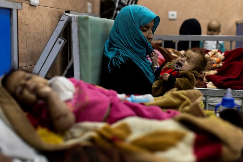 © Reuters. امرأة تحمل طفلها في جناح سوء التغذية الخاص بالرضع في مستشفى أنديرا غاندي للأطفال بكابول يوم السبت. تصوير:رويترز.
