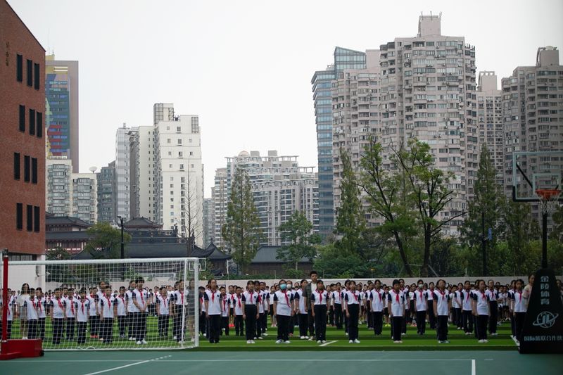 &copy; Reuters. FOTO DE ARCHIVO-Alumnos de pie en una escuela durante una ceremonia de arriado de bandera en el primer día del nuevo año académico en Shanghái, China. 1 de septiembre de 2021. REUTERS/Aly Song