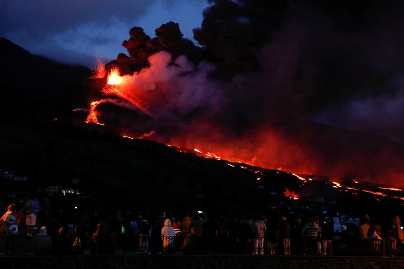 &copy; Reuters. Gente observa cómo el volcán Cumbre Vieja arroja lava y humo mientras sigue en erupción, visto desde Tajuya, en la isla canaria de La Palma, España. 22 de octubre de 2021. REUTERS/Susana Vera