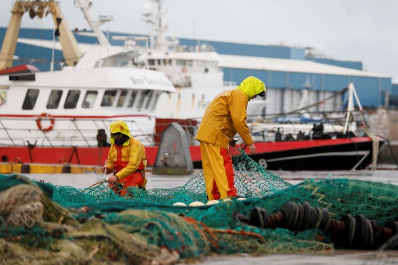 &copy; Reuters. FILE PHOTO: French fishermen repair their nets at Boulogne-sur-Mer after Britain and the European Union brokered a last-minute post-Brexit trade deal, northern France, December 28, 2020. Picture taken December 28, 2020.  REUTERS/Charles Platiau/File Photo